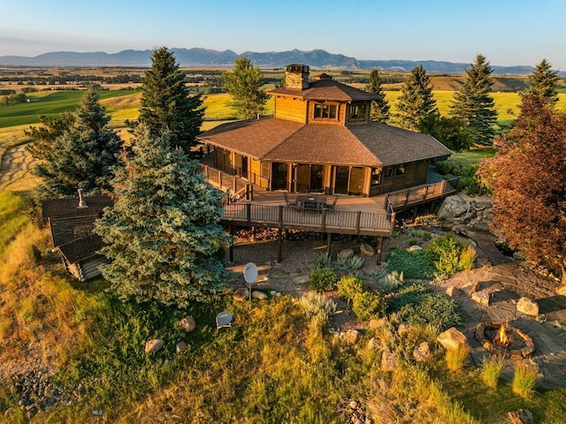 14585 Eagle Eye Way, Gallatin Gateway, MT 59730 - rear view of property featuring a chimney, roof with shingles, a deck with mountain view, and a balcony