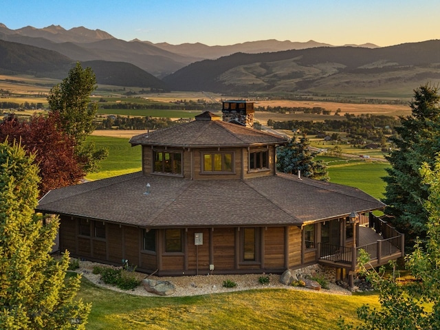 14585 Eagle Eye Way, Gallatin Gateway, MT 59730 - view of front facade featuring a shingled roof, a chimney, a front yard, and a mountain view
