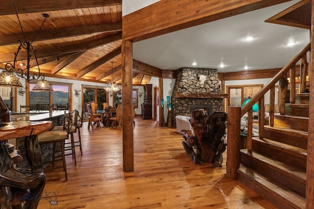 14585 Eagle Eye Way, Gallatin Gateway, MT 59730 - living area with a chandelier, stairway, wood ceiling, a stone fireplace, and hardwood / wood-style floors