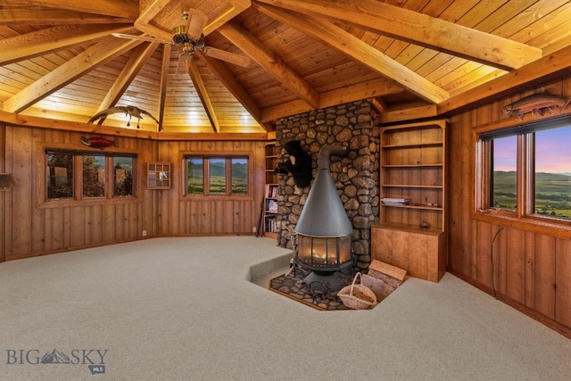 14585 Eagle Eye Way, Gallatin Gateway, MT 59730 - sitting room featuring a wood stove, wood ceiling, wooden walls, carpet flooring, and a ceiling fan