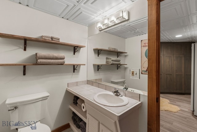 14585 Eagle Eye Way, Gallatin Gateway, MT 59730 - bathroom featuring vanity, toilet, wood finished floors, an ornate ceiling, and baseboards