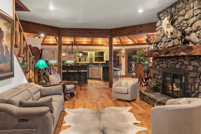 14585 Eagle Eye Way, Gallatin Gateway, MT 59730 - living room with light wood-style floors, a stone fireplace, stairs, and recessed lighting