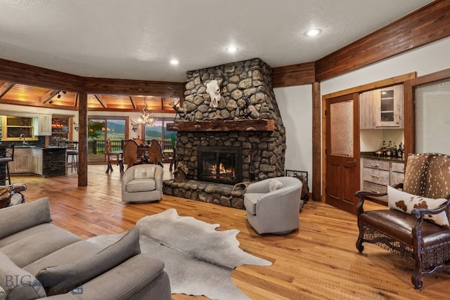 14585 Eagle Eye Way, Gallatin Gateway, MT 59730 - living room featuring light wood-style floors, a chandelier, recessed lighting, and a fireplace