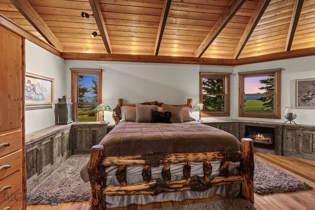 14585 Eagle Eye Way, Gallatin Gateway, MT 59730 - bedroom with wood finished floors, wooden ceiling, a warm lit fireplace, and multiple windows