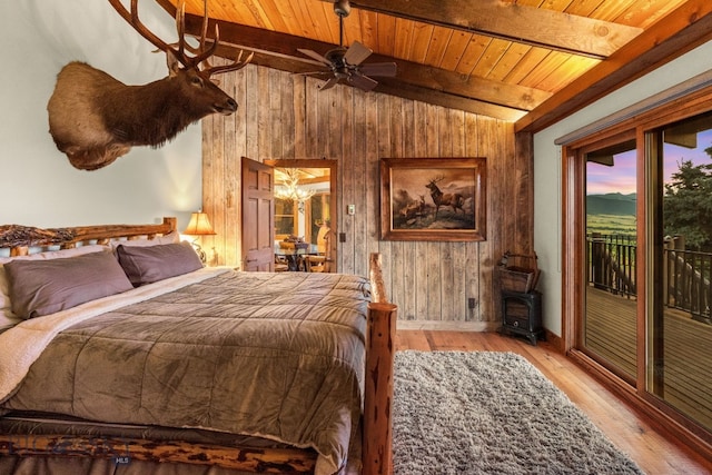 14585 Eagle Eye Way, Gallatin Gateway, MT 59730 - bedroom featuring wooden ceiling, wooden walls, access to exterior, a wood stove, and wood finished floors