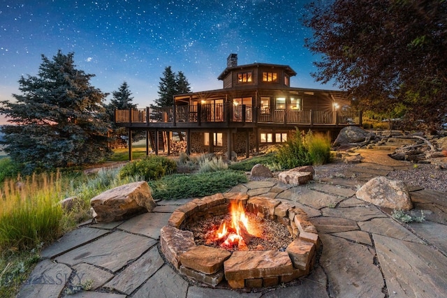 14585 Eagle Eye Way, Gallatin Gateway, MT 59730 - back of property with a fire pit, a deck, and a chimney