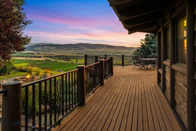 14585 Eagle Eye Way, Gallatin Gateway, MT 59730 - wooden deck featuring a mountain view, an outdoor fire pit, and outdoor dining area
