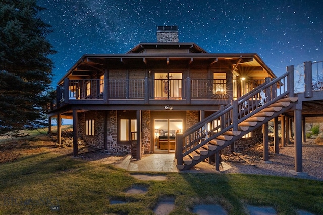 14585 Eagle Eye Way, Gallatin Gateway, MT 59730 - rear view of house featuring a patio, a chimney, stairway, a yard, and a wooden deck