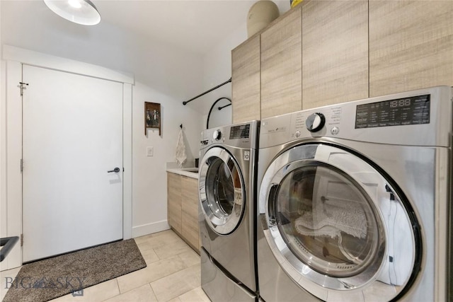 646 Arrow Trl, Bozeman, MT 59718 - laundry area featuring washing machine and clothes dryer, cabinet space, light tile patterned flooring, and baseboards