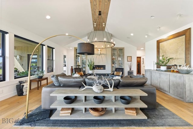 646 Arrow Trl, Bozeman, MT 59718 - living room with lofted ceiling, light wood-style flooring, a fireplace, and a chandelier