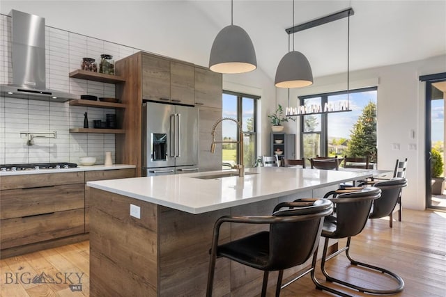646 Arrow Trl, Bozeman, MT 59718 - kitchen with wall chimney range hood, high end refrigerator, a sink, gas stovetop, and open shelves
