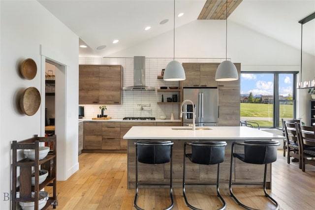 646 Arrow Trl, Bozeman, MT 59718 - kitchen with wall chimney range hood, high end refrigerator, light countertops, a sink, and high vaulted ceiling