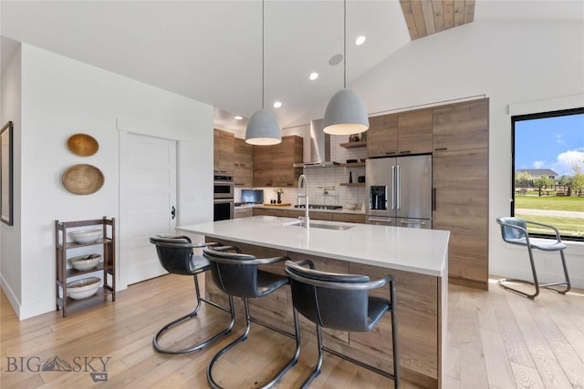646 Arrow Trl, Bozeman, MT 59718 - kitchen featuring stainless steel appliances, light countertops, modern cabinets, light wood-type flooring, and decorative backsplash