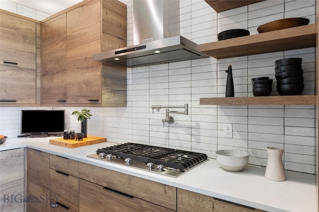 646 Arrow Trl, Bozeman, MT 59718 - kitchen featuring open shelves, wall chimney range hood, stainless steel gas stovetop, decorative backsplash, and light countertops