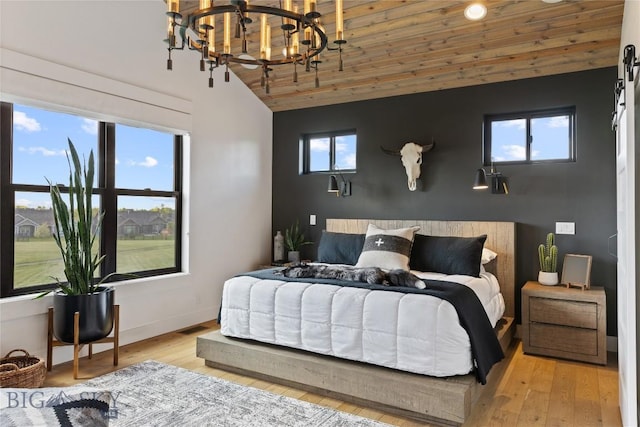 646 Arrow Trl, Bozeman, MT 59718 - bedroom featuring vaulted ceiling, a chandelier, wood ceiling, light wood finished floors, and baseboards