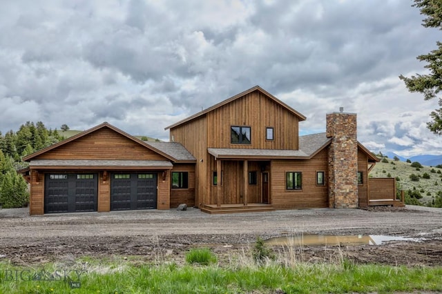 16 Sagittarius Skwy, Emigrant, MT 59027 - view of front of house with a chimney, dirt driveway, an attached garage, a mountain view, and roof with shingles