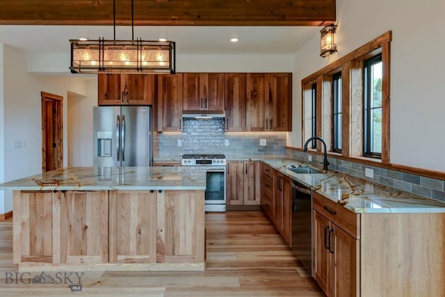 16 Sagittarius Skwy, Emigrant, MT 59027 - kitchen with stainless steel appliances, under cabinet range hood, a sink, light wood-style flooring, and tasteful backsplash