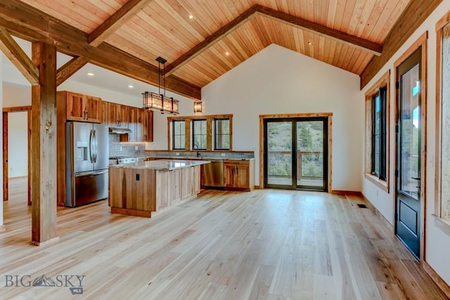 16 Sagittarius Skwy, Emigrant, MT 59027 - kitchen with appliances with stainless steel finishes, brown cabinets, a center island, wooden ceiling with exposed beams, and high vaulted ceiling