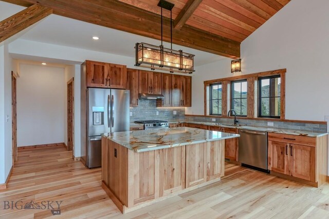 16 Sagittarius Skwy, Emigrant, MT 59027 - kitchen with stainless steel appliances, under cabinet range hood, a sink, light stone countertops, and light wood-style flooring