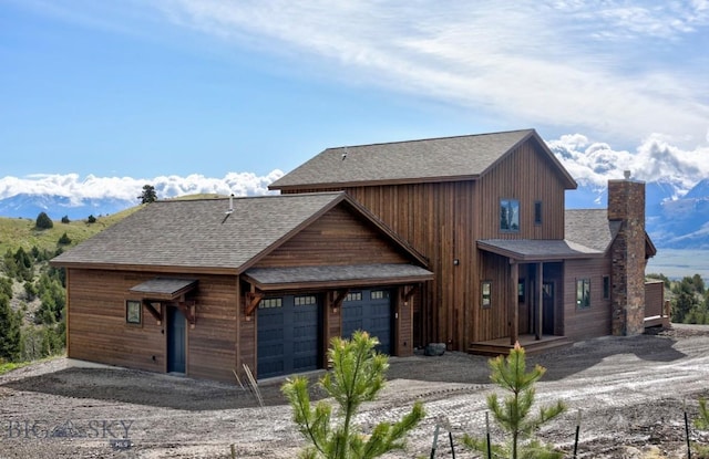 16 Sagittarius Skwy, Emigrant, MT 59027 - view of front facade featuring a shingled roof, a chimney, a garage, and driveway