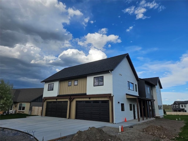 1102 Ridgeview Trl, Livingston, MT 59047 - view of front of house with an attached garage, driveway, board and batten siding, and roof with shingles