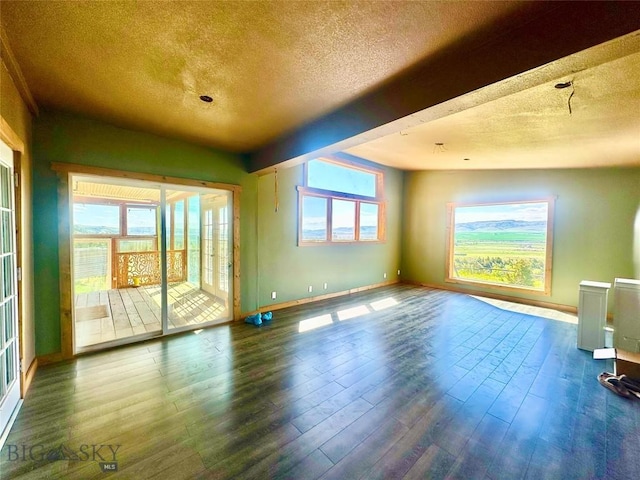 400 Broken Creek Rd, Three Forks, MT 59752 - spare room featuring a textured ceiling, baseboards, healthy amount of natural light, and wood finished floors