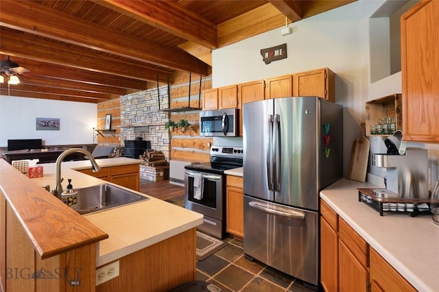 495 Jardine Rd, Gardiner, MT 59030 - kitchen featuring stainless steel appliances, a sink, light countertops, wooden ceiling with exposed beams, and a fireplace