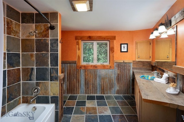 495 Jardine Rd, Gardiner, MT 59030 - bathroom featuring vanity, stone finish floors, bathtub / shower combination, and a wainscoted wall