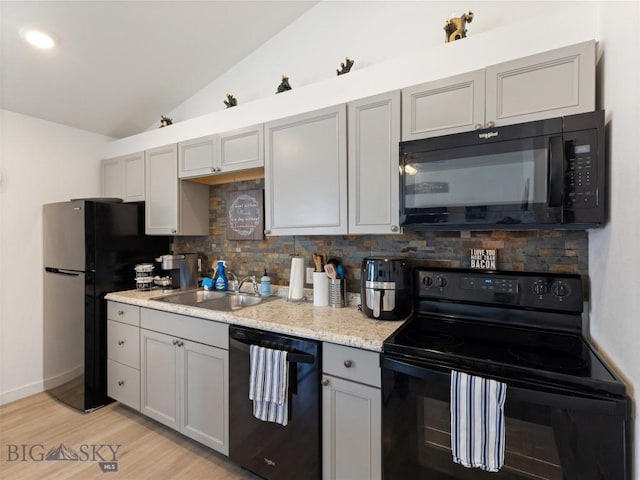407 Brookline St Unit B, Livingston, MT 59047 - kitchen featuring black appliances, a sink, lofted ceiling, gray cabinetry, and decorative backsplash