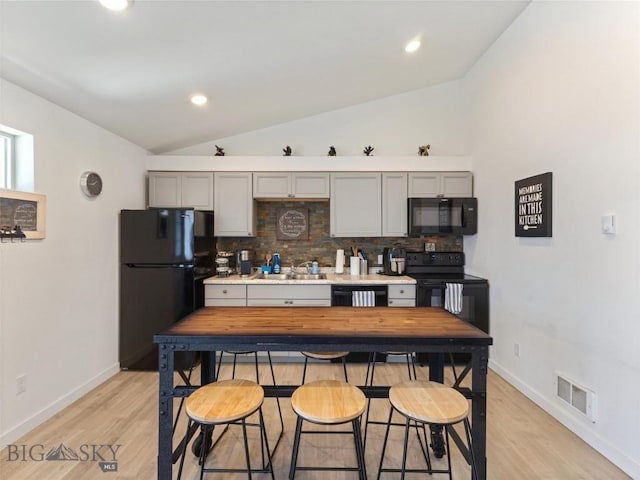 407 Brookline St Unit A, Livingston, MT 59047 - kitchen featuring black appliances, lofted ceiling, a sink, backsplash, and gray cabinetry