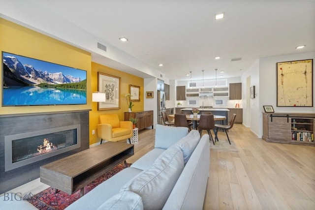 519 E Mendenhall St, Bozeman, MT 59715 - living area featuring light wood-type flooring, a glass covered fireplace, and recessed lighting