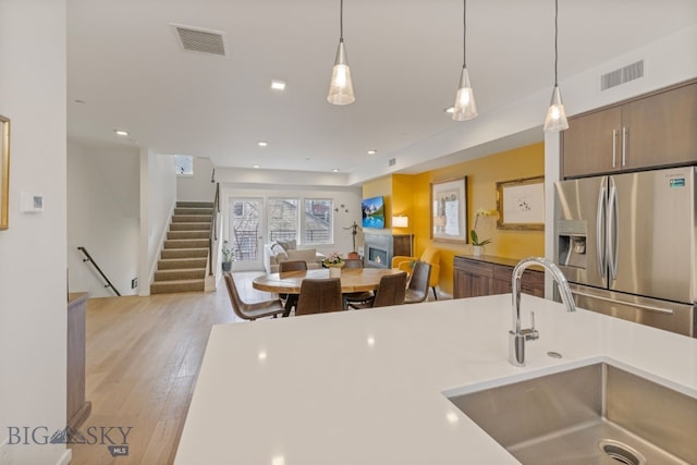 519 E Mendenhall St, Bozeman, MT 59715 - kitchen featuring stainless steel fridge with ice dispenser, a sink, pendant lighting, light wood-type flooring, and light countertops