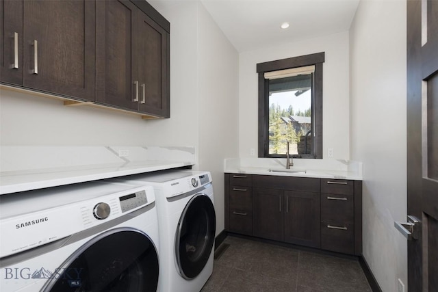 laundry area with washing machine and clothes dryer, cabinet space, baseboards, dark tile patterned floors, and recessed lighting