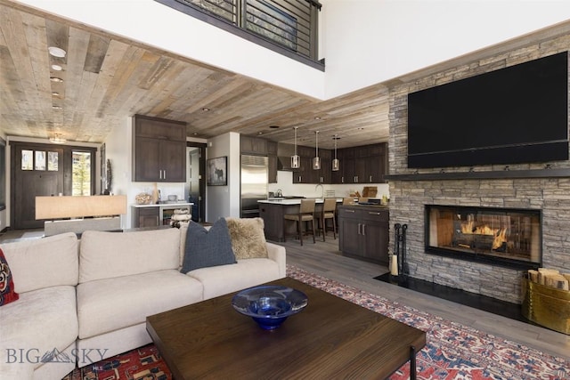 living area featuring wood finished floors, wooden ceiling, and a fireplace