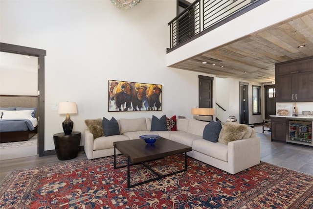 living area featuring wood finished floors, beverage cooler, and bar area