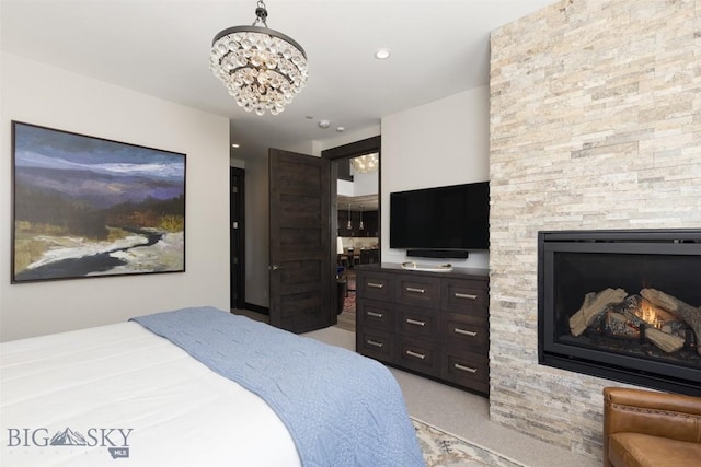 bedroom with light carpet, a fireplace, and a chandelier