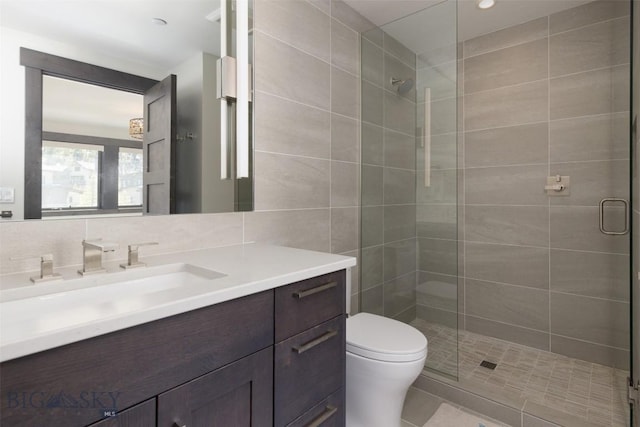 bathroom with vanity, a shower stall, toilet, and tile patterned floors