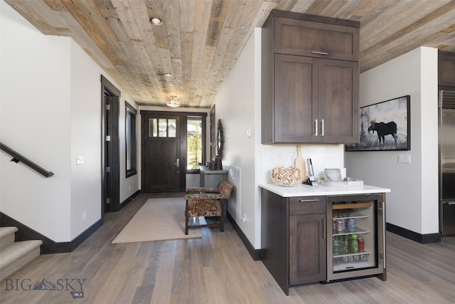 entrance foyer with wine cooler, wooden ceiling, baseboards, wood finished floors, and stairs
