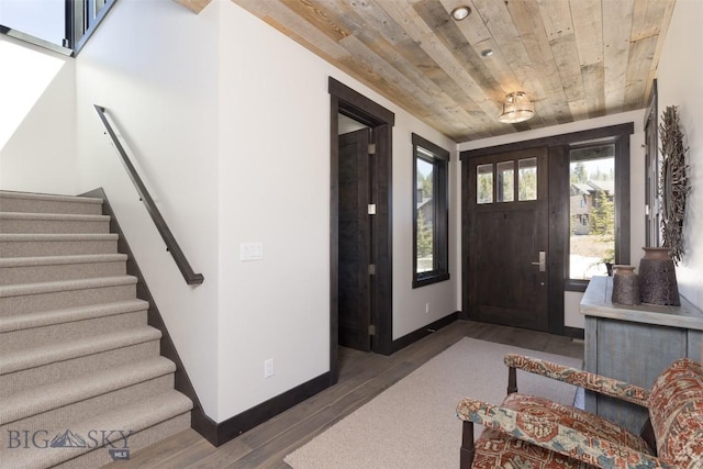 entrance foyer featuring wooden ceiling, wood finished floors, stairway, and baseboards