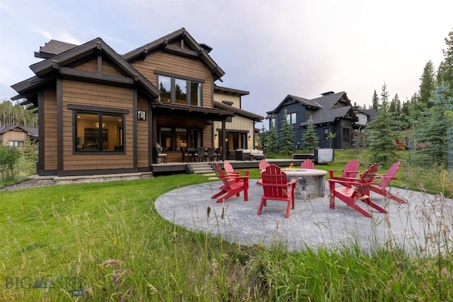 rear view of property with an outdoor fire pit, a lawn, a patio area, and a wooden deck