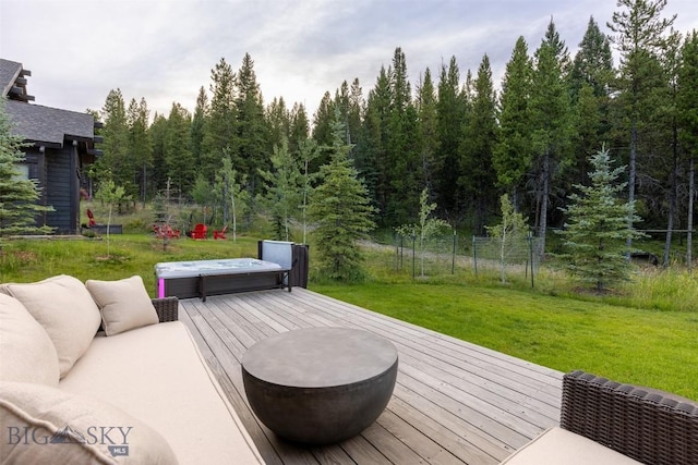 wooden deck featuring a hot tub and a forest view