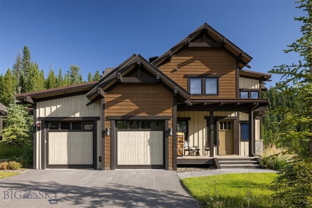 view of front of home featuring a garage, asphalt driveway, covered porch, and board and batten siding