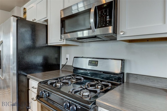 33 Intrepid Dr, Bozeman, MT 59718 - kitchen featuring stainless steel appliances, dark countertops, and white cabinetry