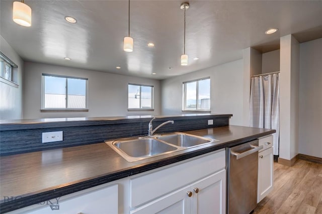 33 Intrepid Dr, Bozeman, MT 59718 - kitchen with dishwasher, dark countertops, white cabinetry, light wood-style flooring, and pendant lighting