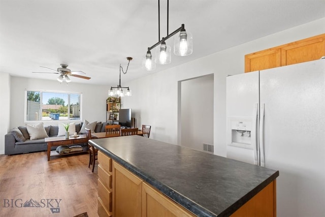 108 10th St Unit B, Belgrade, MT 59714 - kitchen featuring white fridge with ice dispenser, ceiling fan, dark countertops, open floor plan, and light wood-type flooring