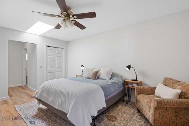 108 10th St Unit B, Belgrade, MT 59714 - bedroom featuring light wood-style flooring, baseboards, ceiling fan, a closet, and a skylight