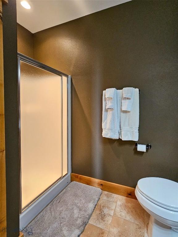 115AND117 Otter Creek Rd, Big Timber, MT 59011 - bathroom featuring a shower stall, toilet, baseboards, and stone finish flooring