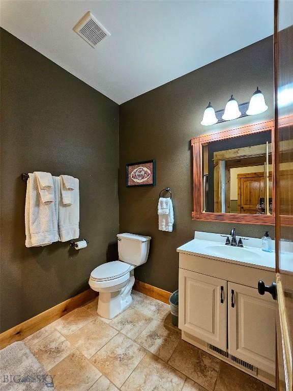 115AND117 Otter Creek Rd, Big Timber, MT 59011 - bathroom featuring baseboards, vanity, toilet, and vaulted ceiling
