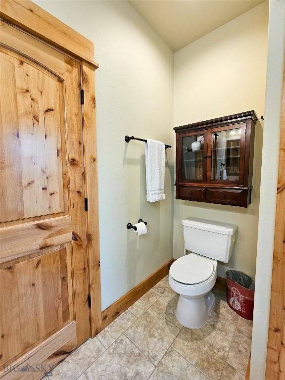 115AND117 Otter Creek Rd, Big Timber, MT 59011 - bathroom featuring toilet, baseboards, and tile patterned flooring