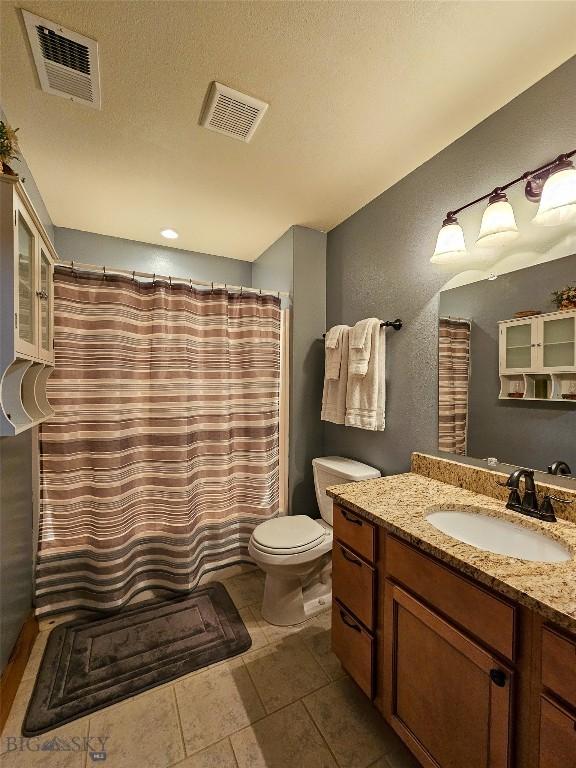 115AND117 Otter Creek Rd, Big Timber, MT 59011 - full bath with toilet, vanity, a textured wall, a textured ceiling, and tile patterned floors